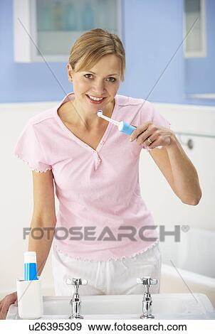 Woman cleaning teeth in bathroom View Large Photo Image Stock Photo - Woman cleaning teeth in bathroom. Fotosearch