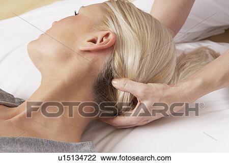 Stock Image - Woman having Shiatsu massage to head. Fotosearch