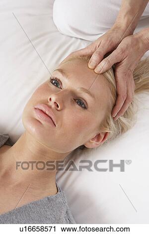 Stock Image - Woman having Shiatsu massage to head. Fotosearch
