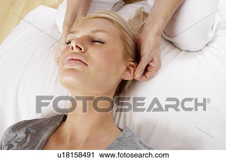 Stock Image - Woman having Shiatsu massage to head. Fotosearch