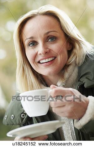 Woman In Outdoor Café With Hot Drink Wearing Winter Clothes View Large Photo Image Stock Image - Woman In Outdoor Café With Hot Drink Wearing Winter Clothes. Fotosearch