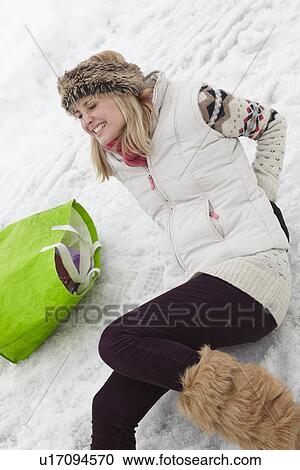 Stock Image - Woman Slipped And Injured Back On Icy Street. Fotosearch