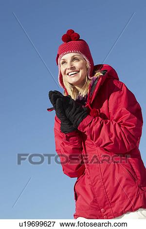 Woman Standing In Snow Wearing Warm Clothes On Ski Holiday In Mountains View Large Photo Image Stock Photo - Woman Standing In Snow Wearing Warm Clothes On Ski Holiday In Mountains. Fotosearch