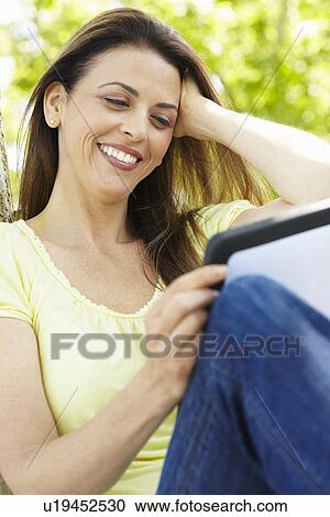 Woman using tablet outdoors View Large Photo Image Stock Image - Woman using tablet outdoors. Fotosearch