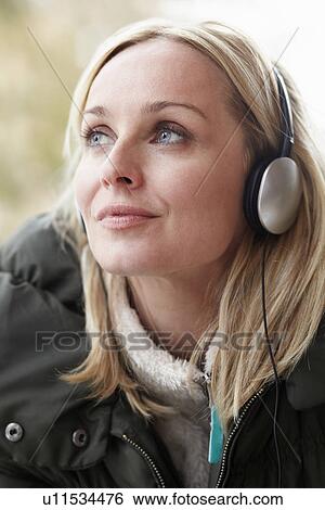 Woman Wearing Headphones And Listening To Music Wearing Winter Clothes View Large Photo Image Stock Photograph - Woman Wearing Headphones And Listening To Music Wearing Winter Clothes. Fotosearch