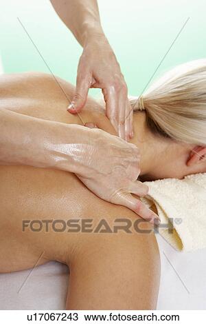 Stock Image - Woman with tattoo having shoulder massage. Fotosearch
