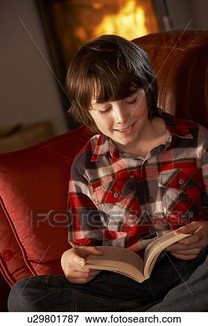 Young Boy Relaxing With Book By Cosy Log Fire View Large Photo Image Stock Photo - Young Boy Relaxing With Book By Cosy Log Fire. Fotosearch