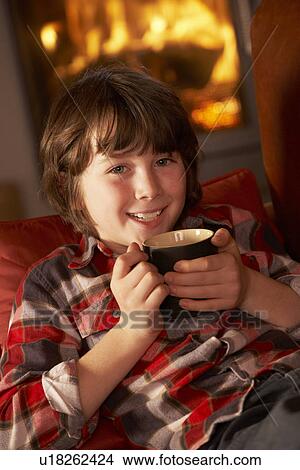Young Boy Relaxing With Hot Drink By Cosy Log Fire View Large Photo Image Picture - Young Boy Relaxing With Hot Drink By Cosy Log Fire. Fotosearch