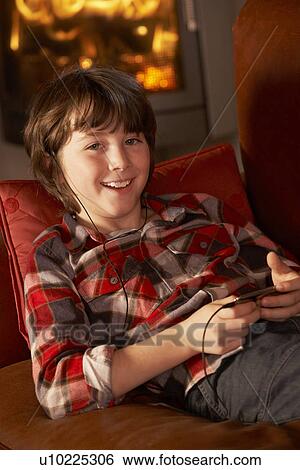 Young Boy Relaxing With MP3 Player By Cosy Log Fire View Large Photo Image Stock Photograph - Young Boy Relaxing With MP3 Player By Cosy Log Fire. Fotosearch