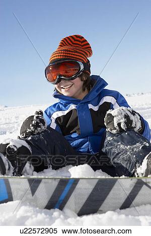 Stock Photography - Young Boy Sitting In Snow With Snowboard. Fotosearch