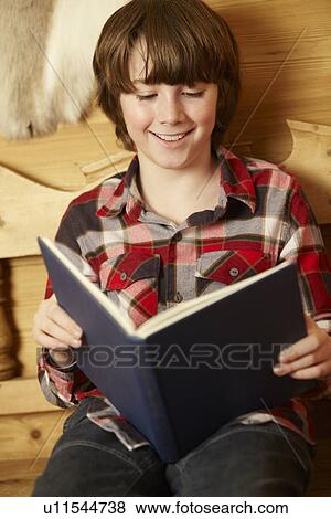 Young Boy Sitting On Wooden Seat Reading Book View Large Photo Image Stock Photo - Young Boy Sitting On Wooden Seat Reading Book. Fotosearch