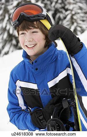 Stock Photo - Young Boy With Snowboard On Ski Holiday In Mountains. Fotosearch