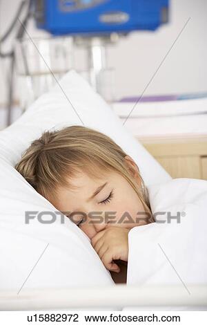 Stock Image - Young girl asleep in Accident and Emergency bed. Fotosearch