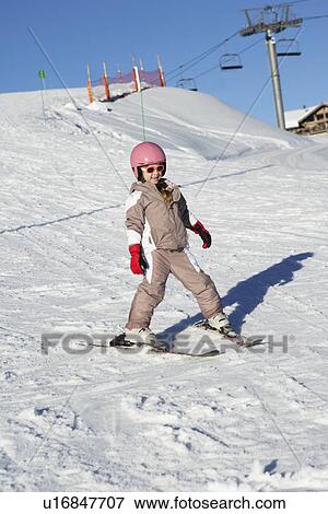 Stock Photo - Young Girl Skiing Down Slope Whilst On Holiday In Mountains. Fotosearch