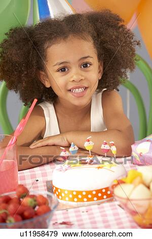 Young girl with birthday cake at party View Large Photo Image Stock Photo - Young girl with birthday cake at party. Fotosearch