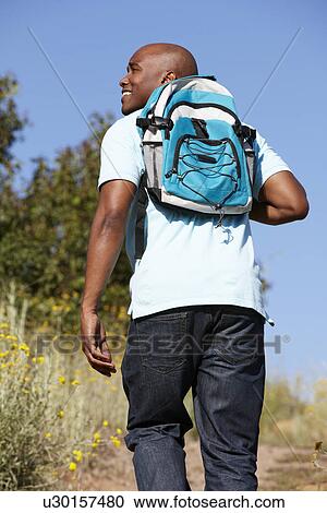 Stock Image - Young man on country hike. Fotosearch