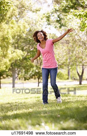Stock Photo - Young woman running in park. Fotosearch