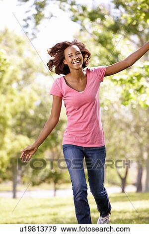 Stock Photo - Young woman running in park. Fotosearch