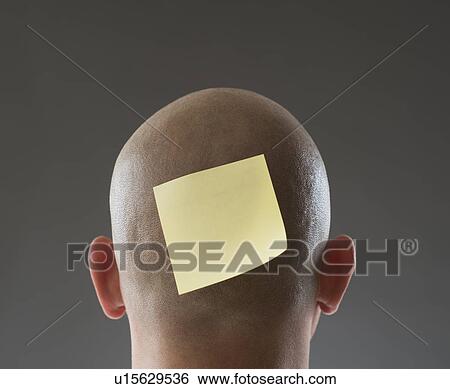 Stock Photograph - Back view of man with adhesive note on shaved head. Fotosearch