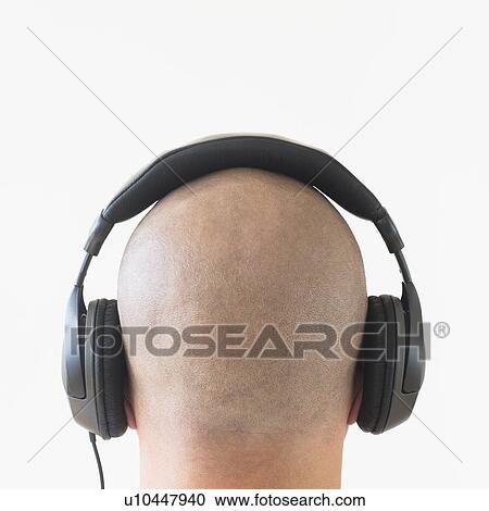 Stock Image - Back view of man with headphones on head. Fotosearch
