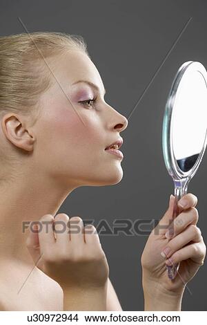 Picture - Beauty portrait of woman looking in mirror. Fotosearch