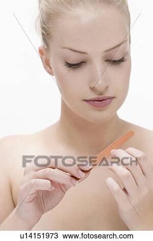 Stock Image - Beauty portrait of woman using nail file. Fotosearch