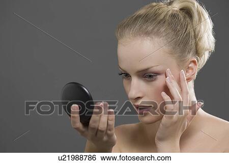 Beauty portrait of woman using powder compact View Large Photo Image Stock Photograph - Beauty portrait of woman using powder compact. Fotosearch
