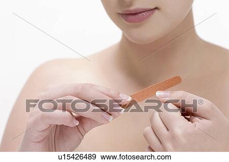 Beauty shot of woman using nail file View Large Photo Image Stock Photo - Beauty shot of woman using nail file. Fotosearch