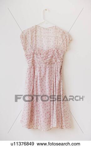 Stock Photo - Blouse with floral pattern on hanger against white wall. Fotosearch