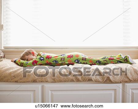 Stock Photo - Boy (6-7) sleeping on bed. Fotosearch