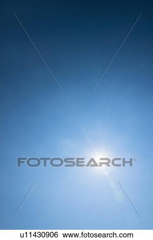 Stock Photograph - Clear blue sky and solar flare. Fotosearch