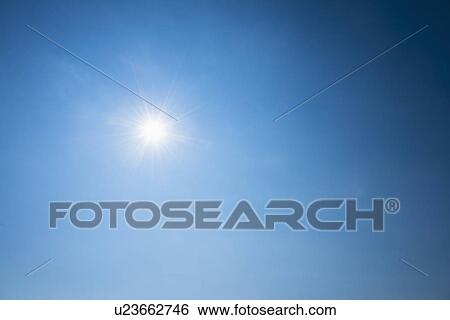 Stock Photograph - Clear blue sky and solar flare. Fotosearch