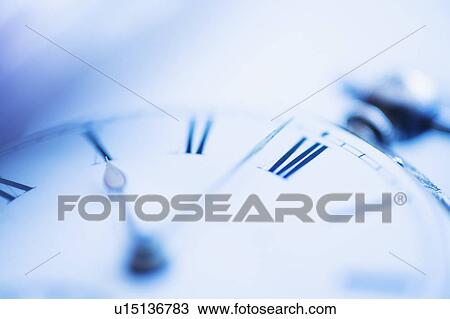 Stock Image - Close-up shot of pocket watch in blue monochrome. Fotosearch
