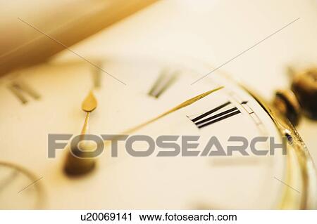 Stock Image - Close-up shot of pocket watch in yellow monochrome. Fotosearch