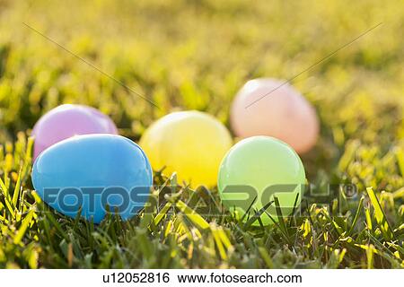 Colorful eggs laying on grass View Large Photo Image Stock Photograph - Colorful eggs laying on grass. Fotosearch