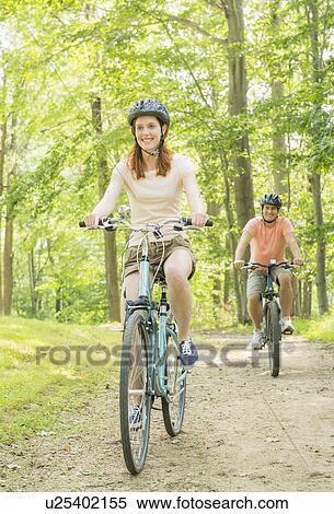 Couple cycling in forest View Large Photo Image Stock Photography - Couple cycling in forest. Fotosearch