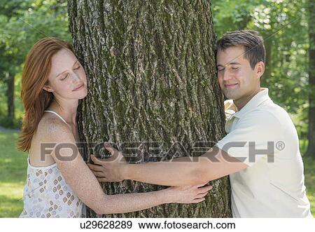 Stock Photo - Couple embracing tree. Fotosearch