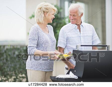 Stock Photo - Couple enjoying barbecue. Fotosearch
