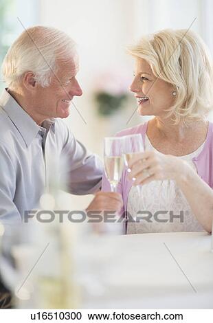 Stock Image - Couple enjoying champagne restaurant. Fotosearch
