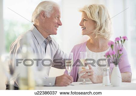 Stock Photo - Couple enjoying champagne restaurant. Fotosearch