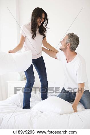 Couple having pillow fight View Large Photo Image Stock Image - Couple having pillow fight. Fotosearch