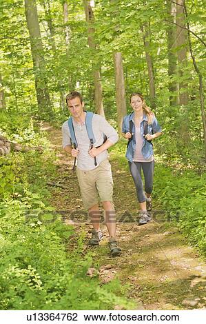 Stock Image - Couple hiking in forest. Fotosearch