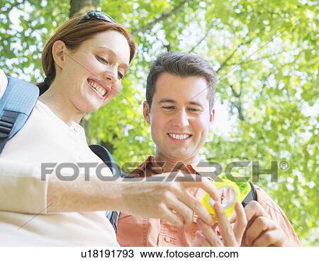 Couple hiking with compass in forest View Large Photo Image Stock Image - Couple hiking with compass in forest. Fotosearch