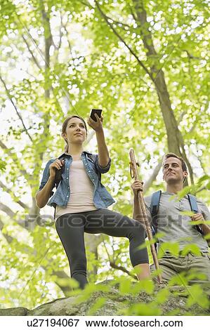 Stock Photo - Couple hiking with GPS in forest. Fotosearch
