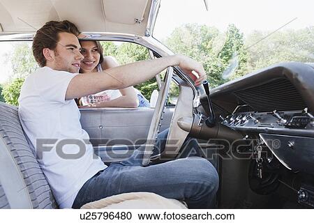 Stock Image - Couple in vintage car. Fotosearch