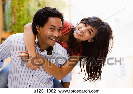 Couple laughing and piggybacking View Large Photo Image Stock Image - Couple laughing and piggybacking. Fotosearch