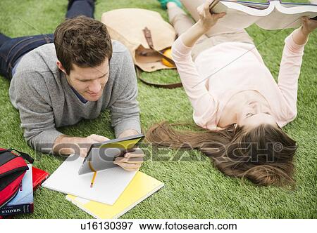 Couple learning on grass View Large Photo Image Stock Photo - Couple learning on grass. Fotosearch