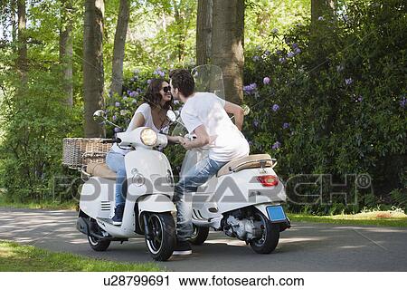 Couple on scooters View Large Photo Image Stock Image - Couple on scooters. Fotosearch