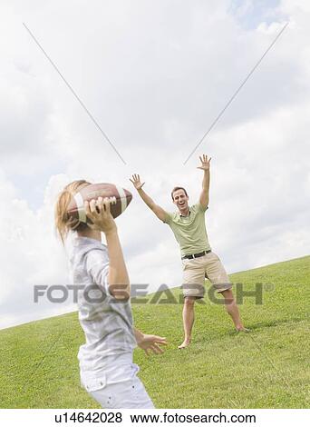 Stock Photo - Couple playing with football. Fotosearch