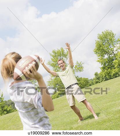 Couple playing with football View Large Photo Image Stock Photograph - Couple playing with football. Fotosearch